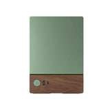 Green electronic device with wooden base on a white background